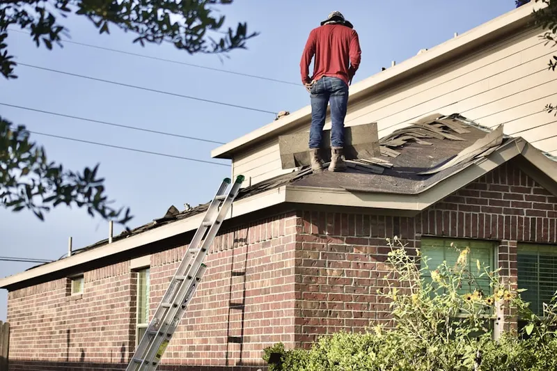Professional roofer working on a residential roof in Youngsdale